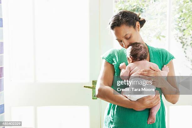 mother holding baby - mom holding baby fotografías e imágenes de stock