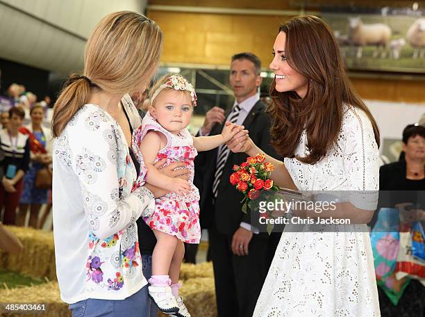 Catherine, Duchess of Cambridge is presented with flowers by a young girl as she visits the Sydney Royal Easter Show on April 18, 2014 in Sydney,...