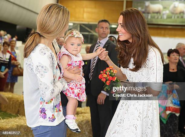 Catherine, Duchess of Cambridge is presented with flowers by a young girl as she visits the Sydney Royal Easter Show on April 18, 2014 in Sydney,...