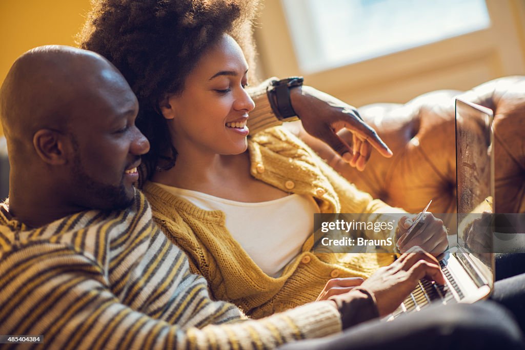Casal americano africano feliz compras on-line em casa.
