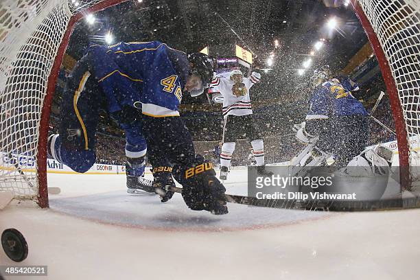 Kris Versteeg of the Chicago Blackhawks celebrates his goal as David Backes of the St. Louis Blues falls into the goal in Game One of the First Round...