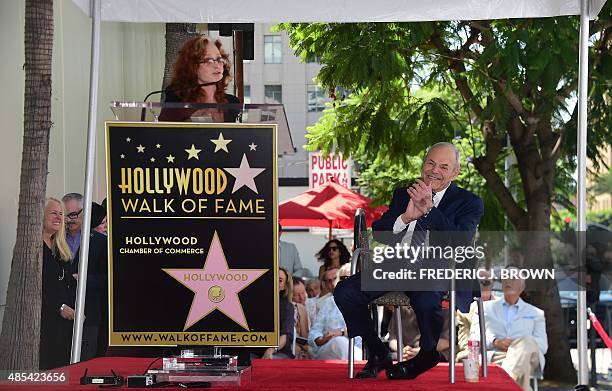 Music executive Joe Smith applauds as musician Bonnie Raitt addresses the audience during Smith's Hollywood Walk of Fame Star ceremony in Hollywood,...