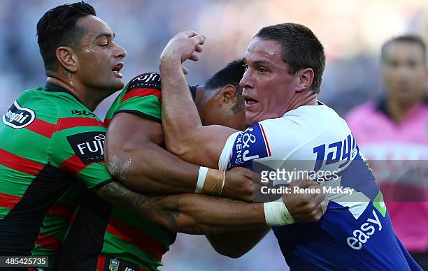 Josh Jackson of the Bulldogs is tackled by John Sutton during the round seven NRL match between the South Sydney Rabbitohs and the...