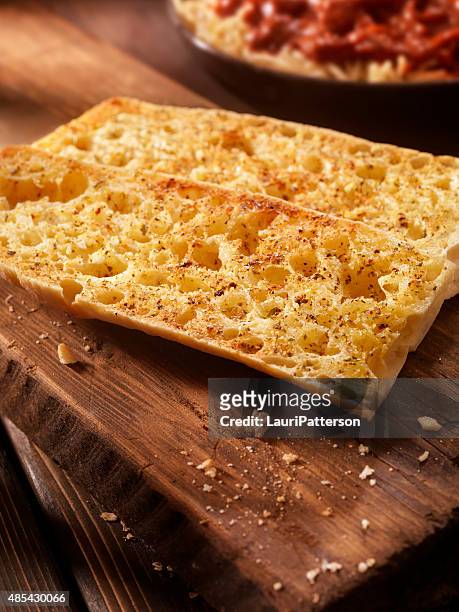 toasted garlic ciabatta bread on a rustic wood cutting board - garlic bread stock pictures, royalty-free photos & images