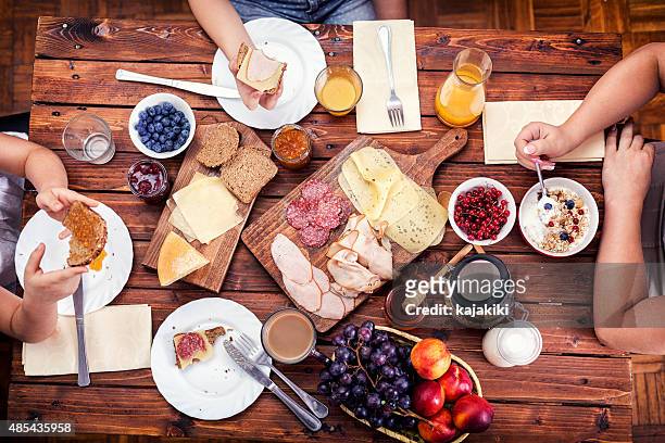 young happy family having breakfast - family orange juice stockfoto's en -beelden
