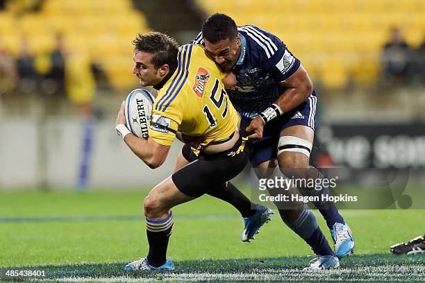 Andre Taylor of the Hurricanes is tackled by Jerome Kaino of the Blues during the round ten Super Rugby match between the Hurricanes and the Blues at...