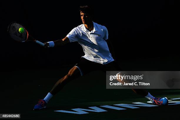Pierre-Hugues Herbert of France returns a shot from Pablo Carreno Busta of Spain during the fourth day of the Winston-Salem Open at Wake Forest...