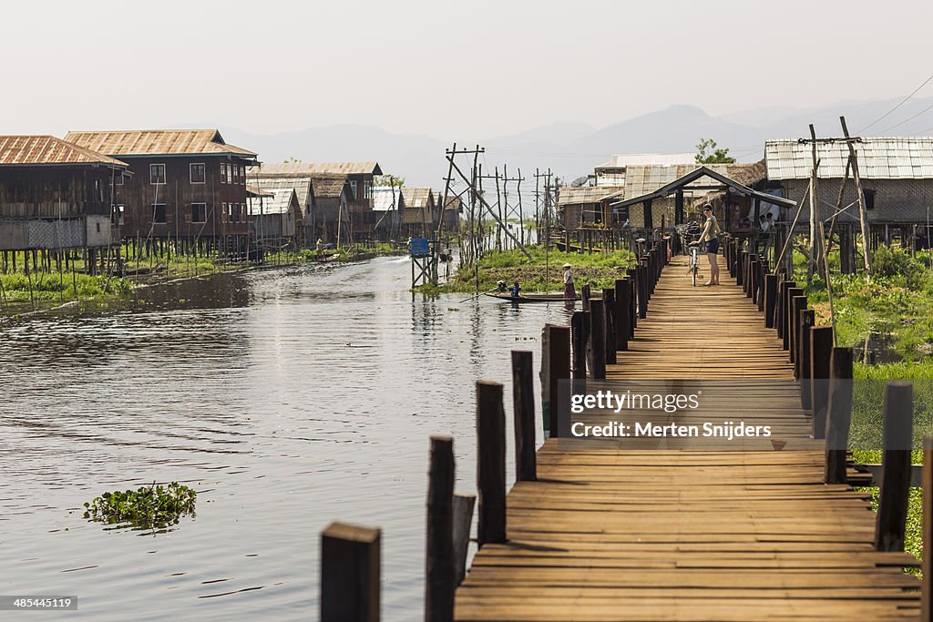 Wooden bridge connecting village and land