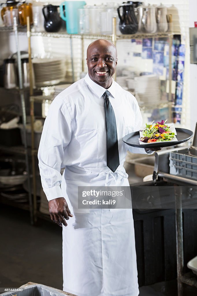 Afro-American cameriere porta un vassoio di cibo