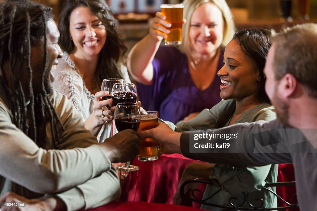 Multiracial group of friends drinking at restaurant bar