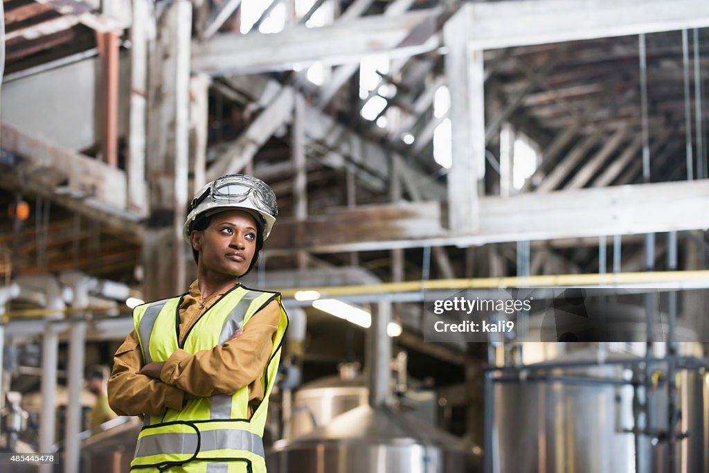 African American woman wearing hardhat and safety vest