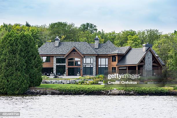 lakefront luxury property on sunny day of summer - waterfront home stock pictures, royalty-free photos & images