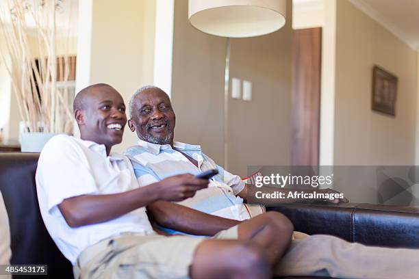 african grandfather and grandson watching television together - old point comfort stock pictures, royalty-free photos & images