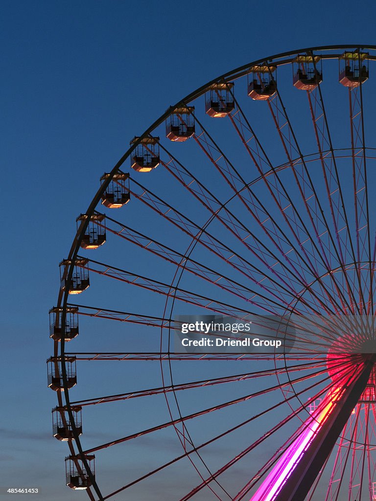 Silhouette of a ferris wheel at dusk