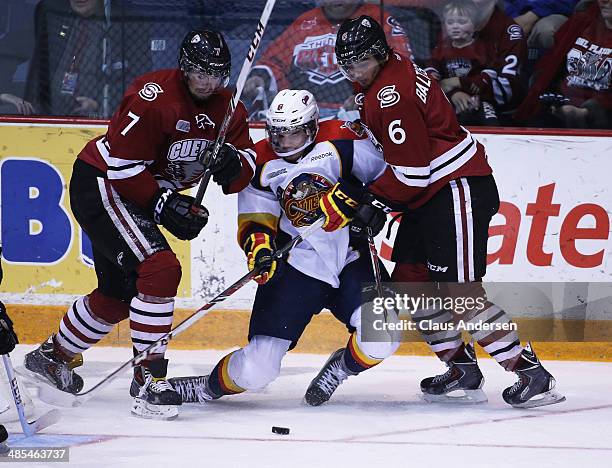 Joel Wigle of the Erie Otters gets sandwiched between Ben Harpur and Phil Baltisberger of the Guelph Storm in Game One of the OHL Western Conference...