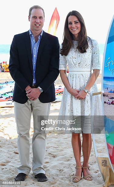 Catherine, Duchess of Cambridge and Prince William, Duke of Cambridge pose with a surfboard they were given as they attend a lifesaving event on...