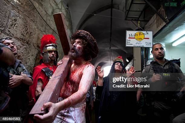Israeli Police officers surround an Orthodox Christian pilgrim from 'The Hope of Glory' order as he re-enacts the Passion of Christ along the Via...