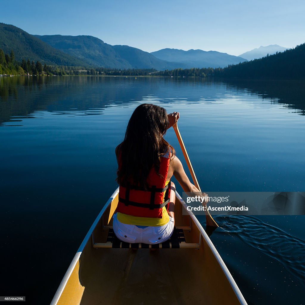Female canoeing on a prisitine lake