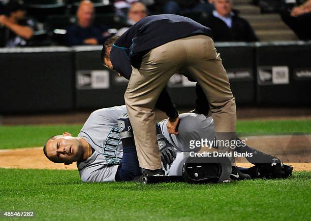 Jesus Montero of the Seattle Mariners reacts after fouling a ball off himself during the fifth inning against the Chicago White Sox on August 27,...