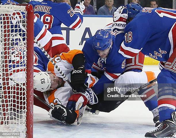 Jakub Voracek of the Philadelphia Flyers is hit by Dan Girardi of the New York Rangers in Game One of the First Round of the 2014 NHL Stanley Cup...