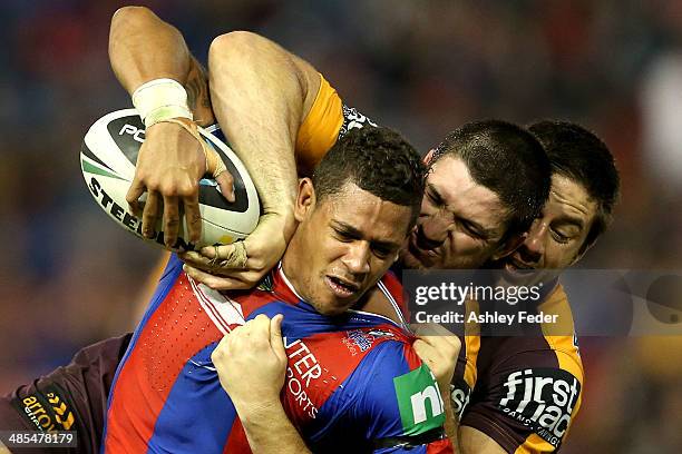 Dane Gagai of the Knights is tackled by Josh McGuire and Ben Hunt of the Broncos during the round seven NRL match between the Newcastle Knights and...