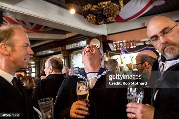 Royal Navel reservists from HMS President laugh during the annual hanging of a hot cross bun at the Widow's Son pub in Bromley-by-Bow on April 18,...