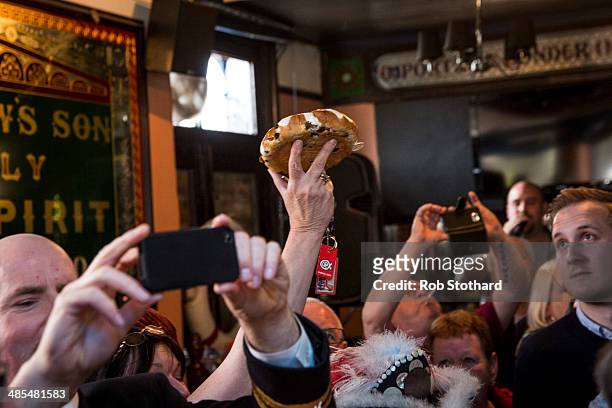 Woman arrives with this year's hot cross bun to be hung in a net above the bar of the Widow's Son pub in Bromley-by-Bow on April 18, 2014 in London,...