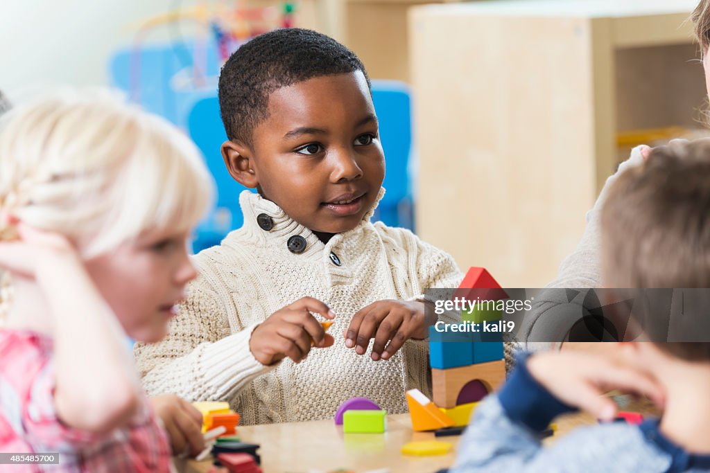 African American boy with friends and building blocks