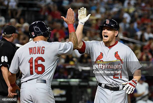 Brandon Moss of the St Louis Cardinals celebrates with teammate Kolten Wong after hitting a home run during the fifth inning against the Arizona...