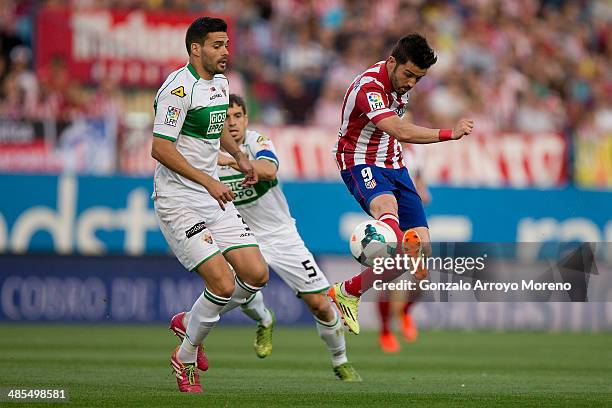 David Villa of Atletico de Madrid competes for the ball with Alberto Tomas Botia of Elche FC during the La Liga match between Club Atletico de Madrid...