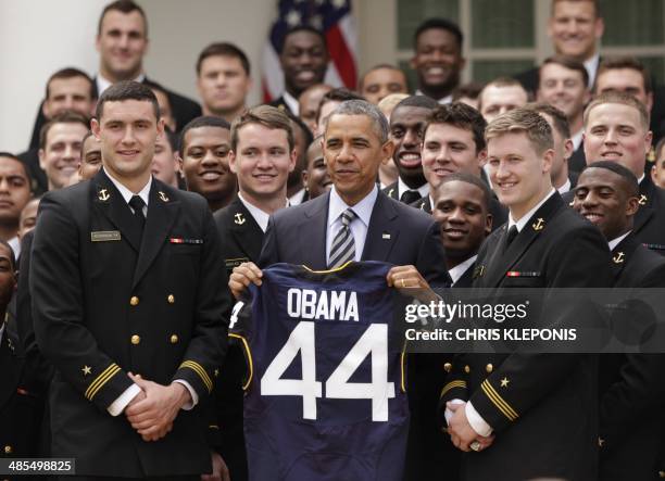 President Barack Obama holds a jersey given to him by the US Naval Academy Football Team during the presentation of the Commander-in-Chief Trophy at...