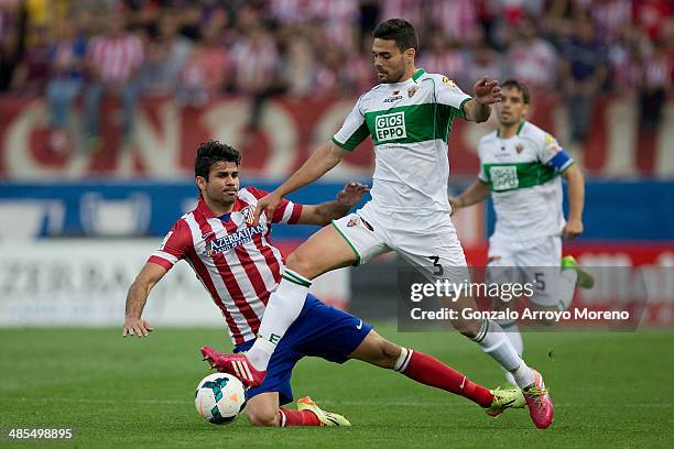 Alberto Tomas Botia of Elche FC tackles Diego Costa of Atletico de Madrid during the La Liga match between Club Atletico de Madrid and Elche FC at...