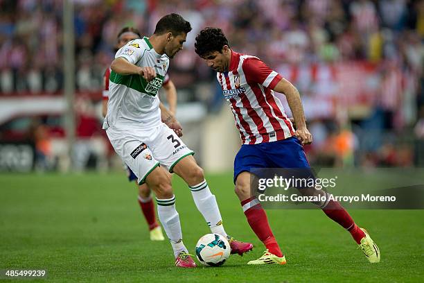 Diego Costa of Atletico de Madrid competes for the ball with Alberto Tomas Botia of Elche FC during the La Liga match between Club Atletico de Madrid...