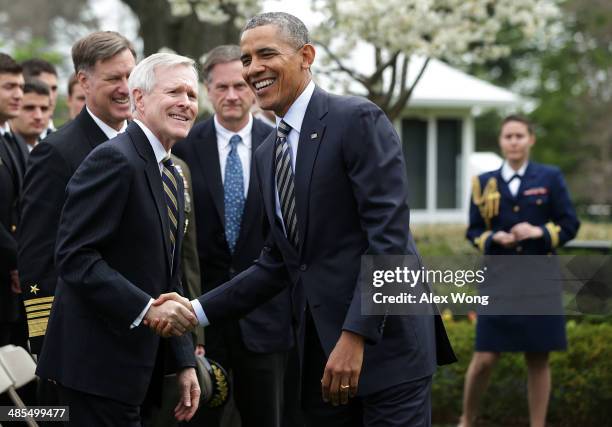 President Barack Obama shakes hands with Secretary of the Navy Ray Mabus as he hosts the United States Naval Academy football team during a...