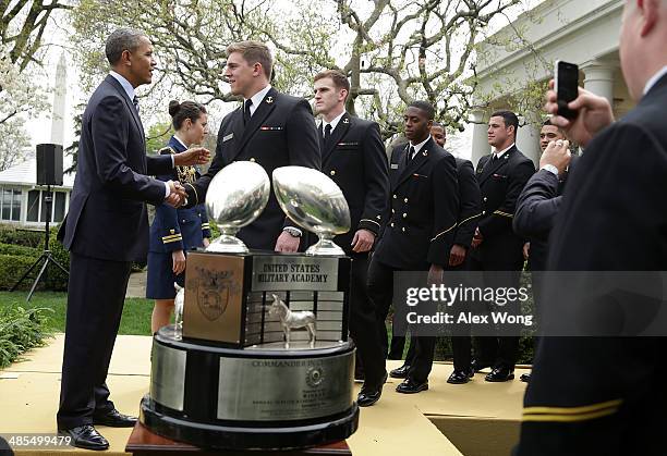 President Barack Obama greets members of the United States Naval Academy football team during a presentation ceremony of the Commander-in-Chief's...