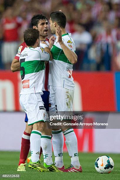 Diego Costa of Atletico de Madrid argues with Alberto Rivera of Elche FC and his teammate Alberto Tomas Botia during the La Liga match between Club...