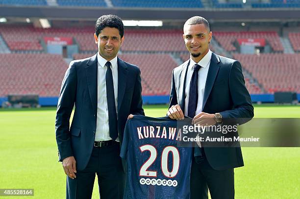 Layvin Kurzawa poses with his new jersey next to Nasser Al-Khelaifi, President of PSG, during his presentation to the media at Parc des Princes on...