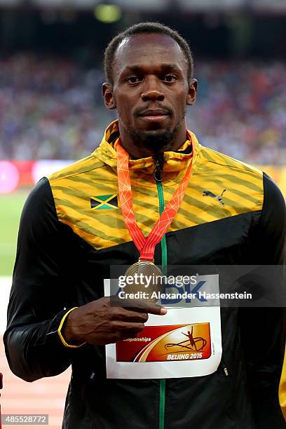 Gold medalist Usain Bolt of Jamaica poses on the podium during the medal ceremony for the Men's 200 metres final during day seven of the 15th IAAF...