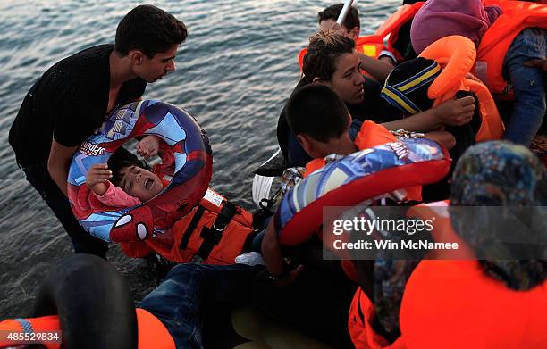 Members of a migrant family from Syria embrace each other after completing a three mile crossing of the Aegean Sea to the island of Kos from Turkey...