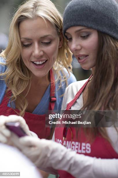 Actresses Allison McAtee and Oksana Grigorieva look at a selfie at The Los Angeles Mission's Easter Celebration Of New Life For The Homeless at Los...