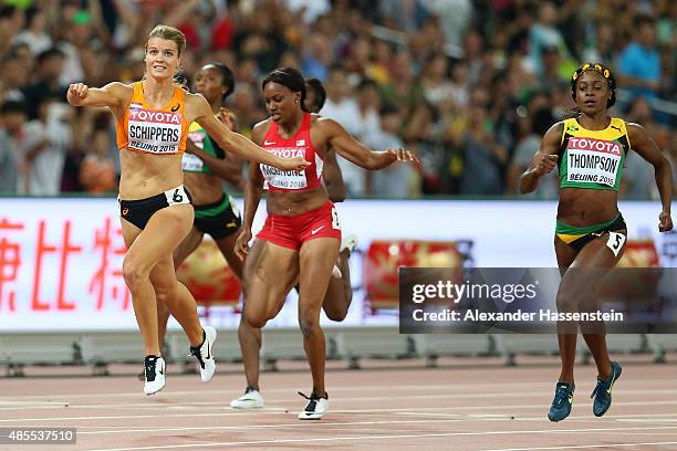 Dafne Schippers of the Netherlands crosses the finish line to win gold in the Women's 200 metres final ahead of second placed Elaine Thompson of...