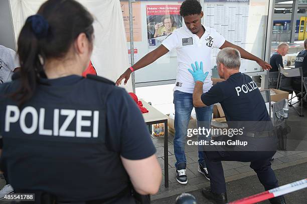 Police conduct an inital registration and search of a migrant who had arrived with aprroximately 30 others by train at the main train station on...