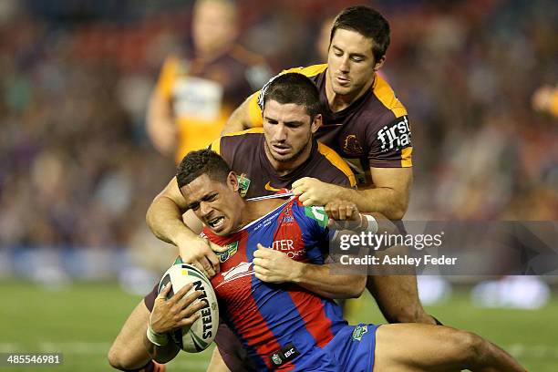 Dane Gagai of the Knights is tackled by Josh McGuire and Ben Hunt of the Broncos during the round seven NRL match between the Newcastle Knights and...