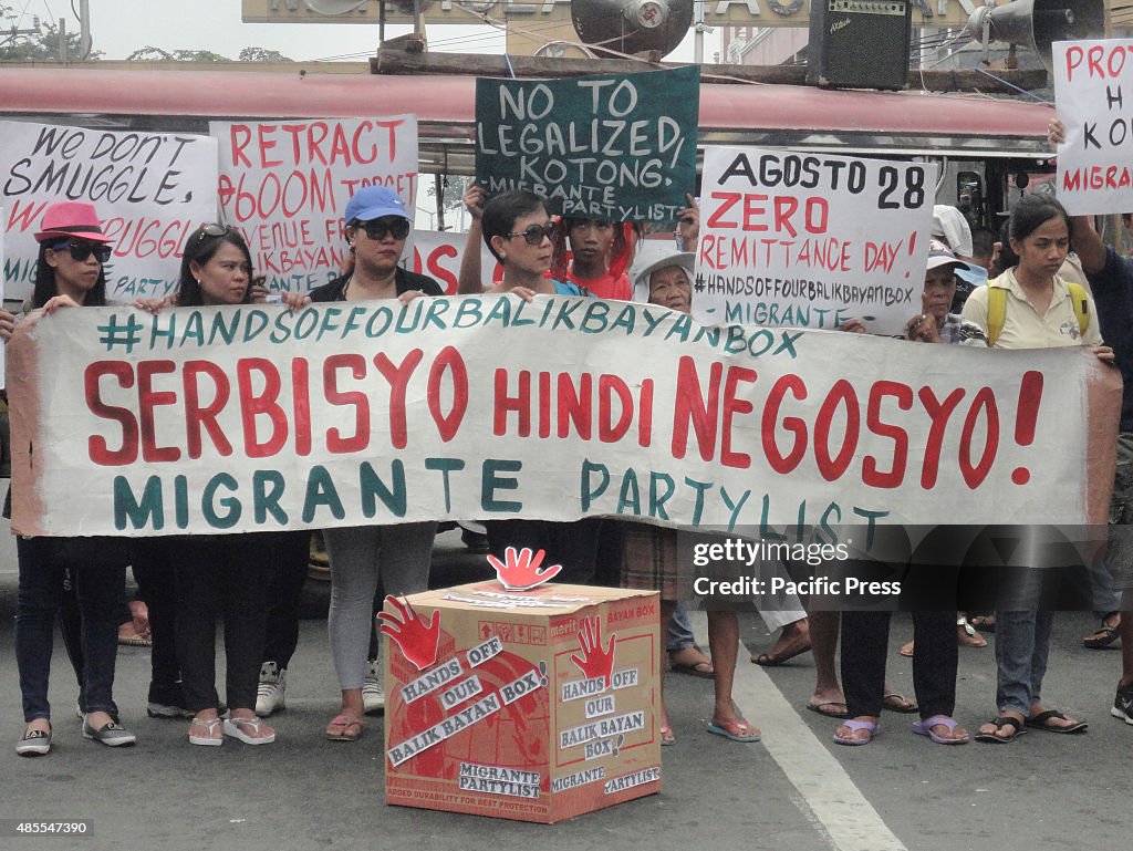 Filipino migrant workers hold slogans as they protest the...
