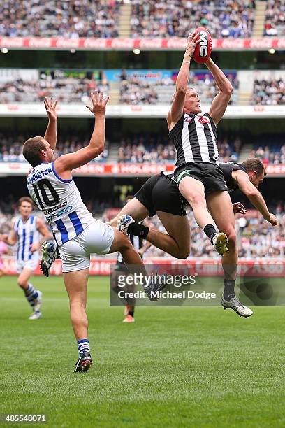 Jack Frost of the Magpies marks the ball against Ben Cunnington of the Kangaroos and teamate Nick Maxwell during the round five AFL match between the...