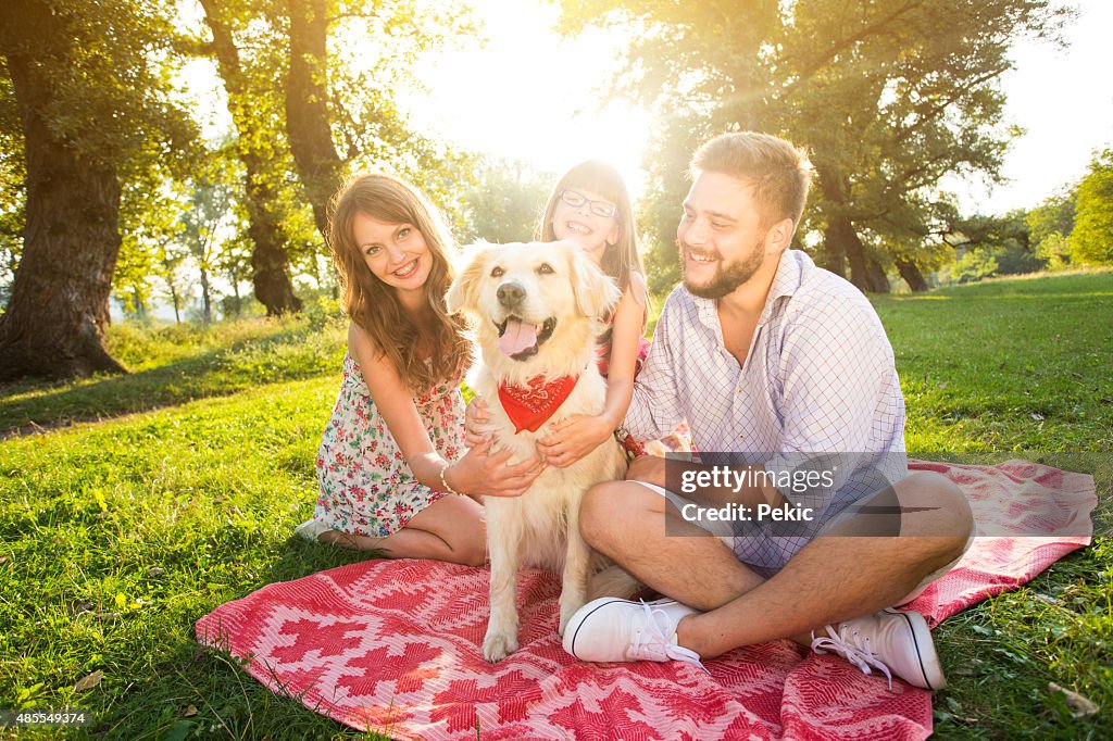 Familia joven feliz en un día de verano con su perro