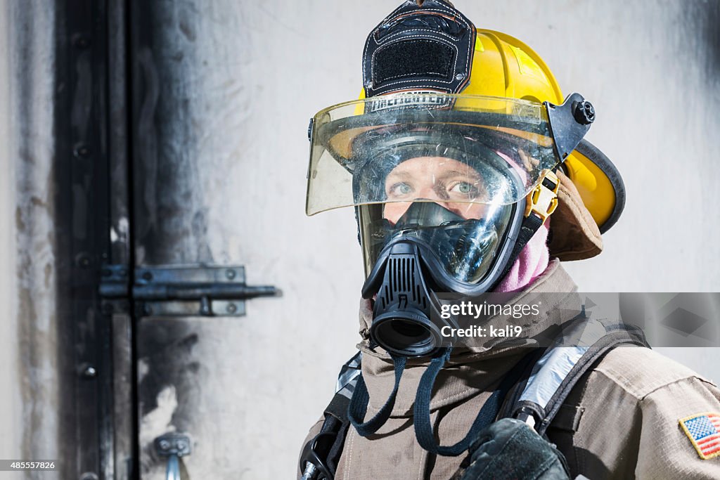 Female firefighter in protective gear and oxygen mask