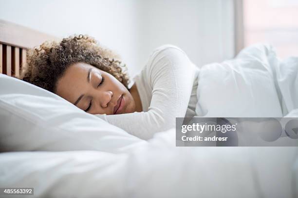 black woman sleeping in bed - bedtime stockfoto's en -beelden