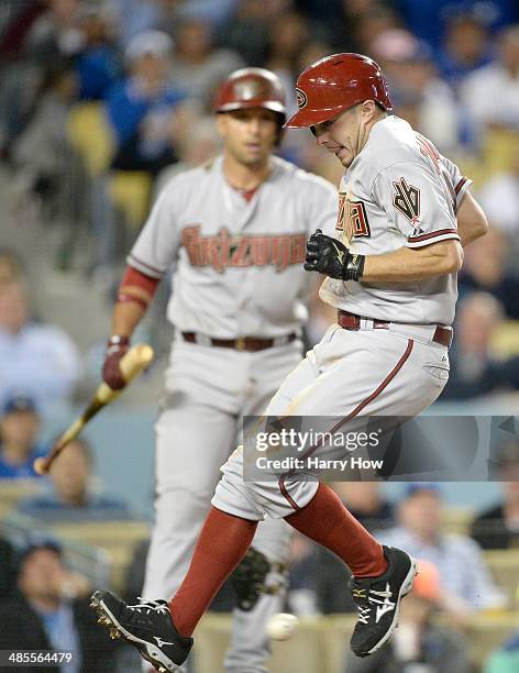 Tony Campana of the Arizona Diamondbacks reacts as he crosses the plate ahead of a throw after a wild pitch by Chris Withrow of the Los Angeles...