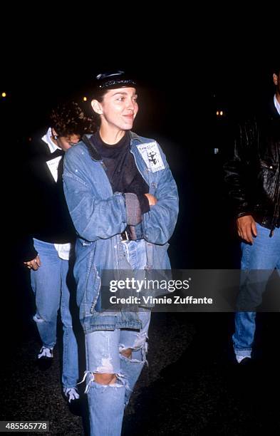 Singer Madonna walks in the street wearing waist high blue jeans and a jean jacket in November, 1988 in New York, New York.